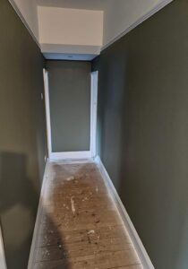 hallway painted in dark olive green with white woodwork